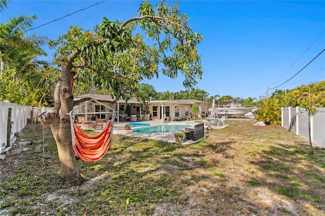 view of yard with a fenced in pool, a fenced backyard, and a patio area