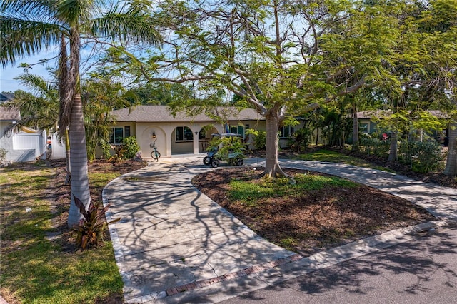 single story home featuring stucco siding and curved driveway