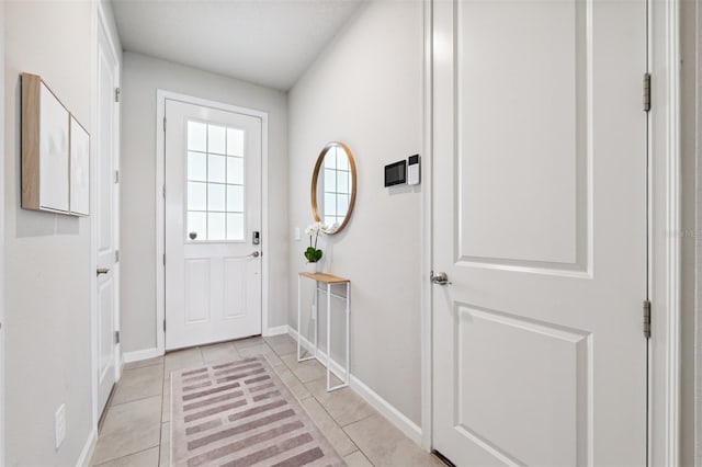 entryway with baseboards and light tile patterned floors