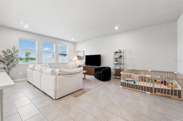 living area featuring baseboards, recessed lighting, light tile patterned flooring, and visible vents