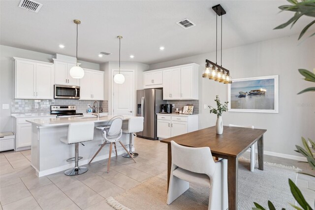 kitchen featuring a sink, appliances with stainless steel finishes, tasteful backsplash, and visible vents