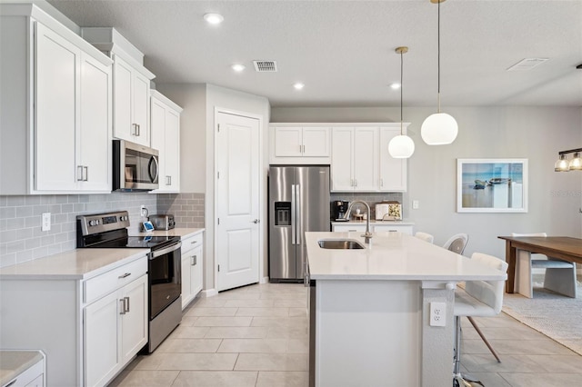 kitchen featuring visible vents, light tile patterned flooring, light countertops, a sink, and stainless steel appliances