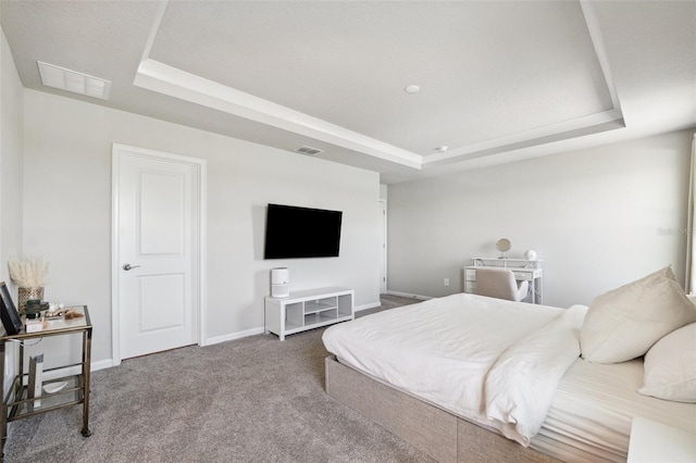 bedroom featuring visible vents, carpet flooring, and a raised ceiling