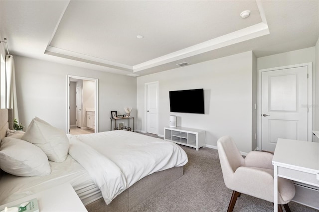 bedroom featuring visible vents, baseboards, connected bathroom, a tray ceiling, and carpet flooring