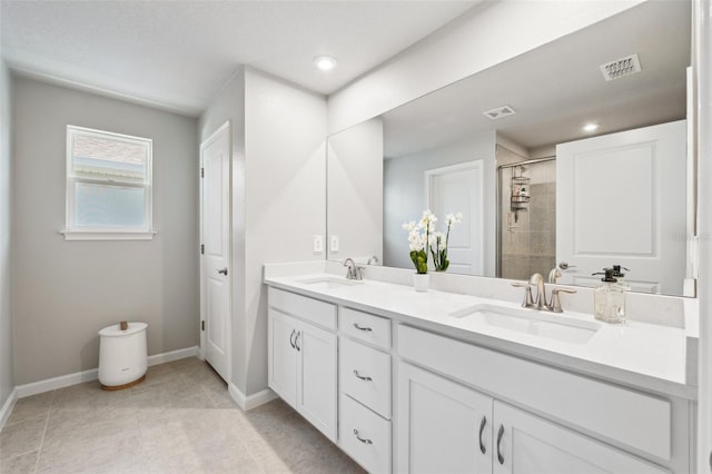 bathroom featuring a sink, baseboards, a stall shower, and visible vents