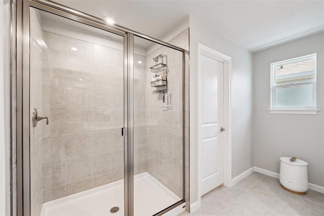bathroom featuring tile patterned floors, baseboards, and a stall shower