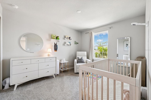 bedroom featuring a nursery area, baseboards, and carpet flooring