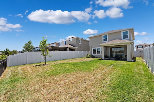 back of house with a yard, a fenced backyard, and stucco siding