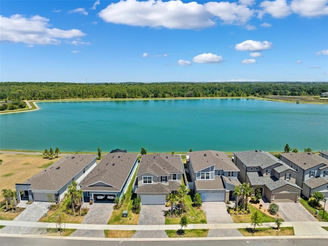 aerial view featuring a water view, a view of trees, and a residential view