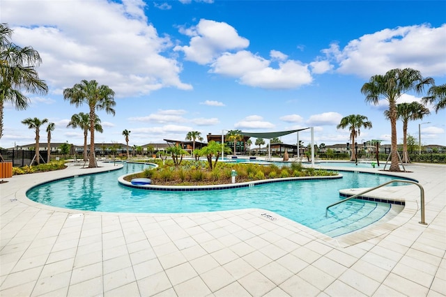 community pool featuring a patio and a water slide