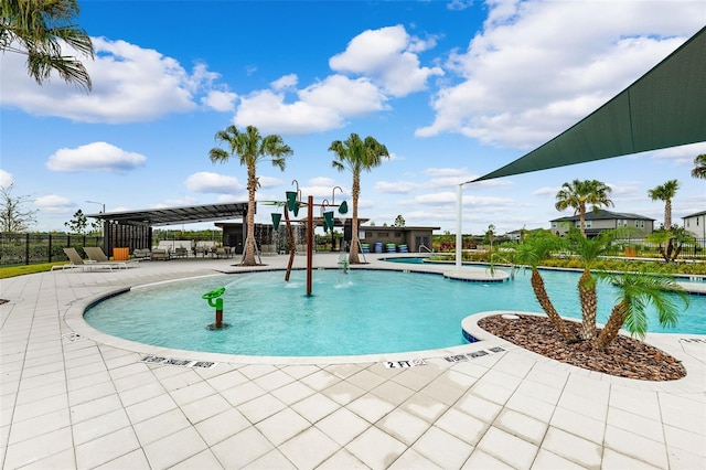 pool featuring fence, a patio, and a water play area