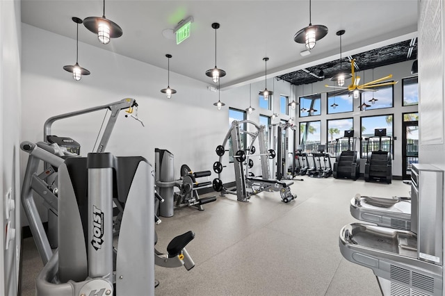 exercise room featuring a towering ceiling and ceiling fan