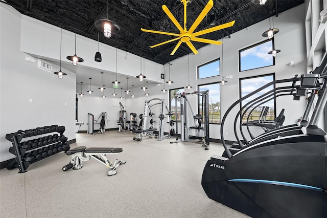gym with baseboards, a high ceiling, and visible vents