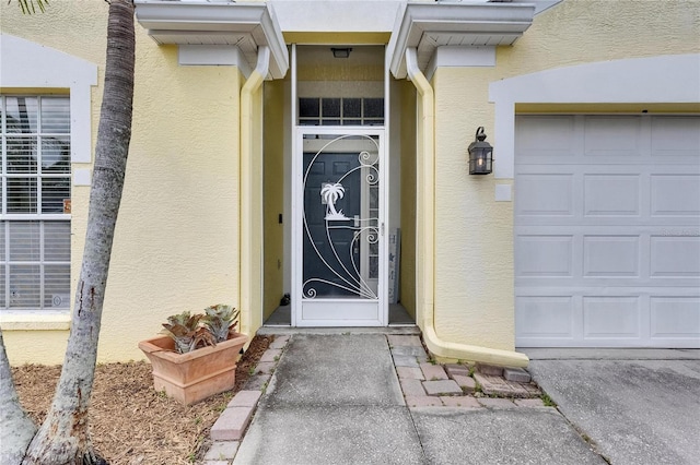 entrance to property featuring stucco siding and an attached garage