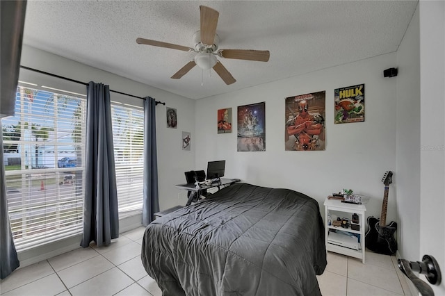 bedroom with light tile patterned floors, a textured ceiling, and a ceiling fan