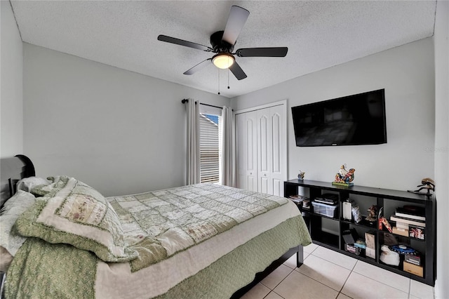 tiled bedroom featuring a closet, a textured ceiling, and a ceiling fan
