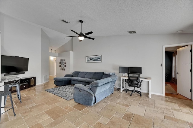 living area with stone tile flooring, an office area, a ceiling fan, a textured ceiling, and high vaulted ceiling