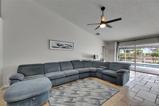 living area with a textured ceiling, ceiling fan, lofted ceiling, and stone tile flooring