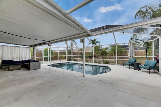 view of swimming pool featuring glass enclosure, a patio area, and a fenced backyard