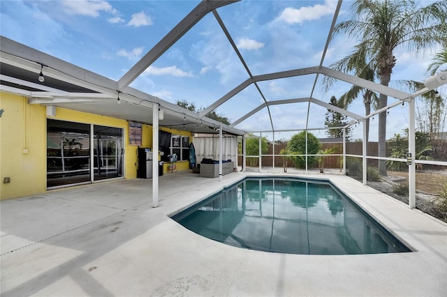 view of swimming pool featuring a patio area, a fenced backyard, and glass enclosure