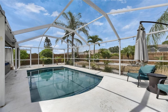 view of swimming pool with a fenced backyard, glass enclosure, and a patio area