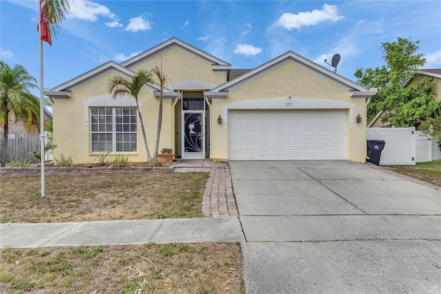 ranch-style house featuring stucco siding, fence, driveway, and an attached garage