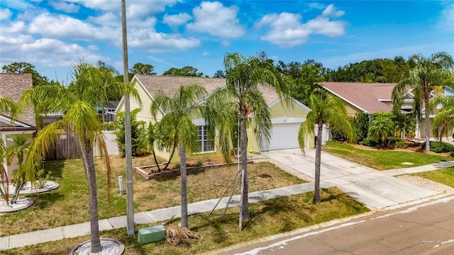 view of front facade with concrete driveway, a front yard, and stucco siding