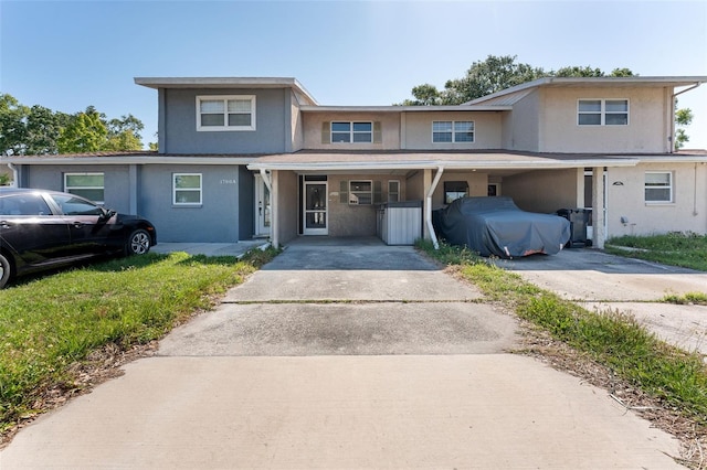 view of front of property featuring a porch, aphalt driveway, and stucco siding