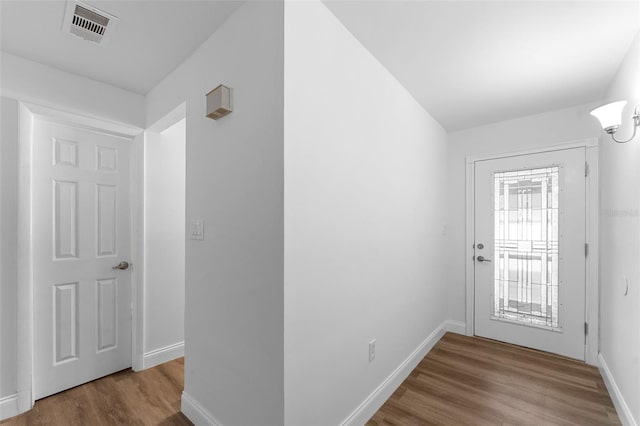 doorway featuring wood finished floors, visible vents, and baseboards