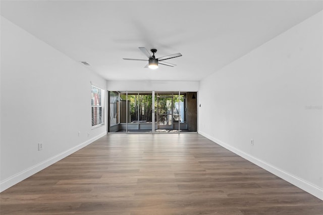 empty room with baseboards, a ceiling fan, and wood finished floors