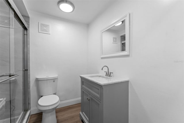 full bath with a shower stall, toilet, vanity, and wood finished floors