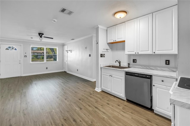 kitchen with a sink, visible vents, crown molding, light countertops, and stainless steel dishwasher
