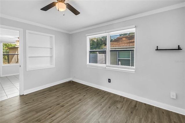 unfurnished room featuring baseboards, a healthy amount of sunlight, ceiling fan, and built in features