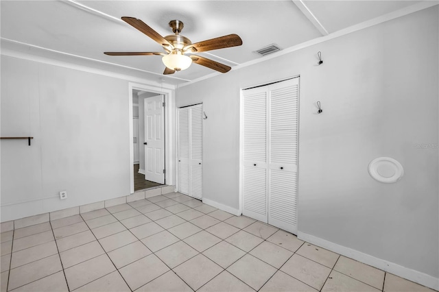unfurnished bedroom with light tile patterned floors, baseboards, visible vents, and a ceiling fan