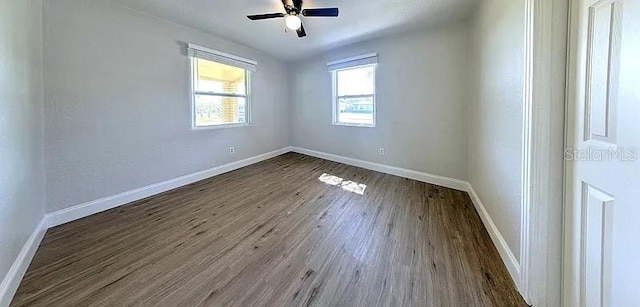 spare room with baseboards, ceiling fan, and wood finished floors