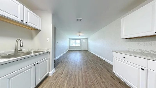 kitchen featuring light countertops, visible vents, baseboards, and a sink
