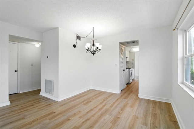 unfurnished dining area with baseboards, visible vents, a notable chandelier, and light wood-style flooring