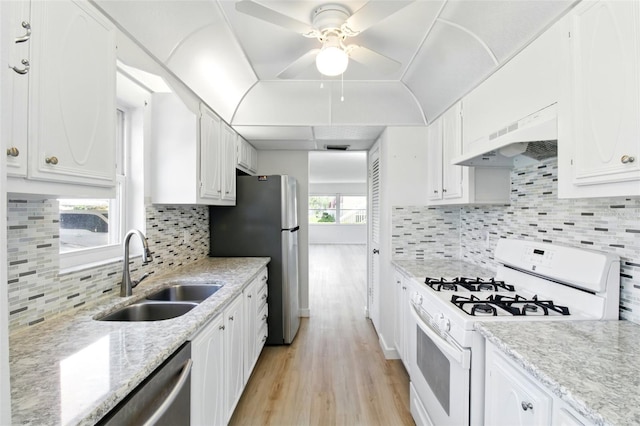kitchen featuring light wood finished floors, a sink, under cabinet range hood, ceiling fan, and appliances with stainless steel finishes