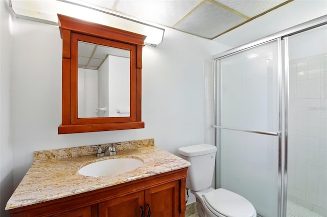 full bathroom featuring a shower stall, toilet, and vanity