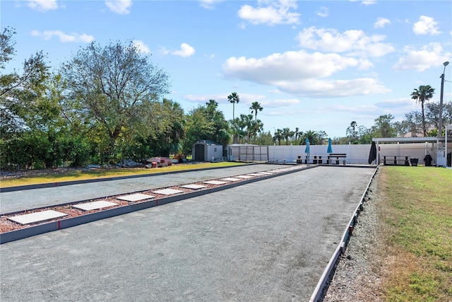 view of home's community with fence, a storage unit, and an outdoor structure