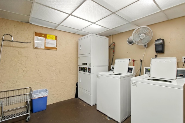 community laundry room with stacked washer and dryer, separate washer and dryer, and a textured wall