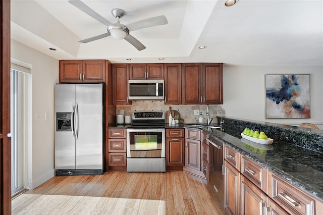 936 Pinellas Bayway S Unit T-5, Tierra Verde, FL 33715 - kitchen with stainless steel appliances, a sink, decorative backsplash, light wood-style flooring, and ceiling fan