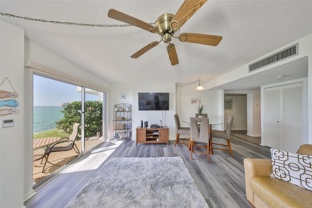 1301 Gulf Blvd Unit 107, Clearwater Beach, FL 33767 - living room featuring a textured ceiling, wood finished floors, ceiling fan, and baseboards