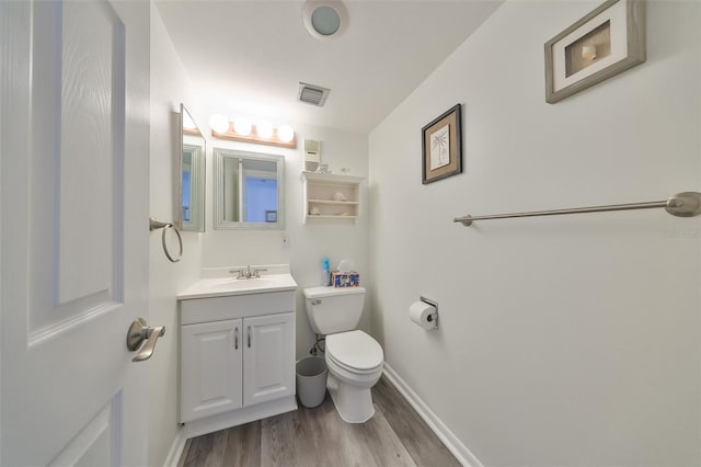 1301 Gulf Blvd Unit 107, Clearwater Beach, FL 33767 - bathroom featuring wood finished floors, vanity, toilet, and baseboards