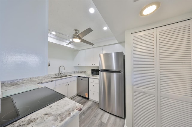 1301 Gulf Blvd Unit 107, Clearwater Beach, FL 33767 - kitchen with appliances with stainless steel finishes, a sink, light wood-style flooring, white cabinets, and recessed lighting