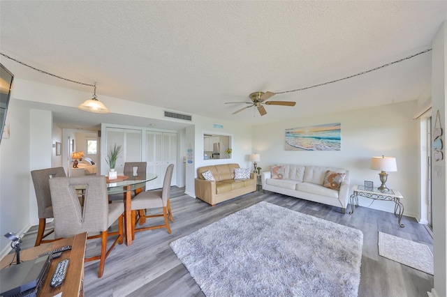 1301 Gulf Blvd Unit 107, Clearwater Beach, FL 33767 - living room with wood finished floors, ceiling fan, a textured ceiling, and baseboards