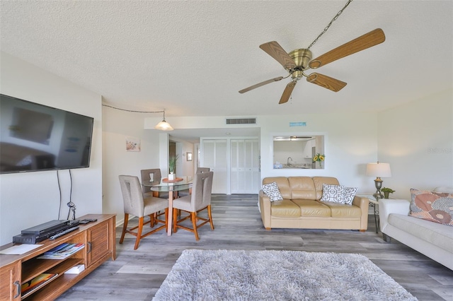 1301 Gulf Blvd Unit 107, Clearwater Beach, FL 33767 - living area featuring wood finished floors, ceiling fan, and a textured ceiling