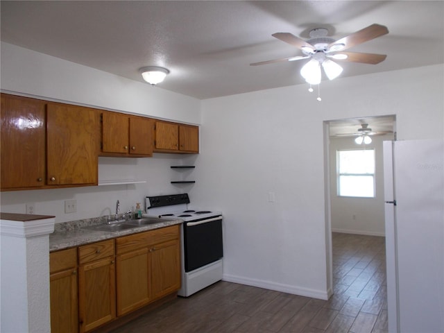 433 73rd Ave N, Saint Petersburg, FL 33702 - kitchen with a sink, brown cabinets, electric range oven, dark wood-style floors, and freestanding refrigerator