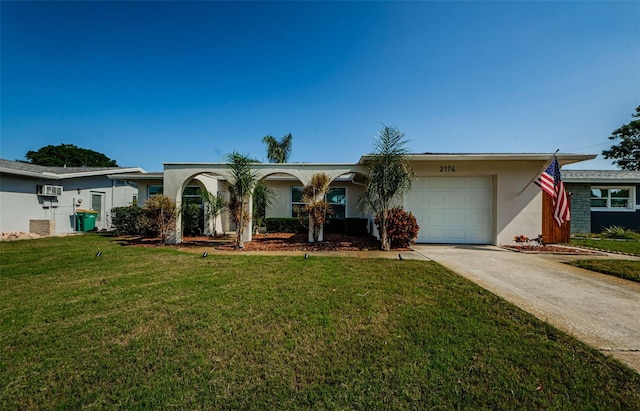 single story home with stucco siding, driveway, a front yard, and an attached garage
