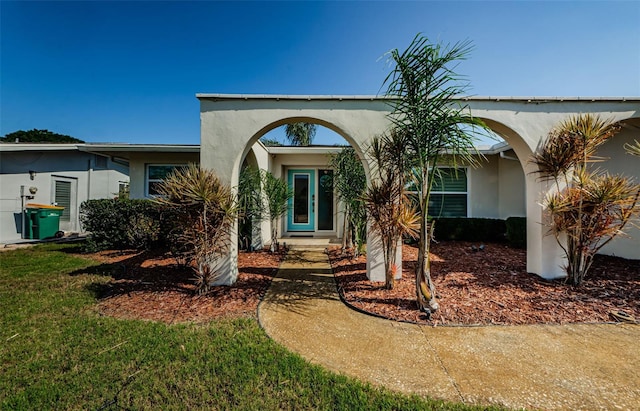 single story home featuring stucco siding and a front lawn